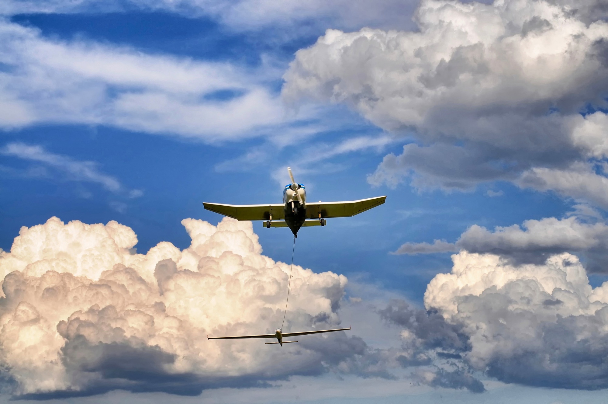 Low angle shot of plane under blue cloudy sky